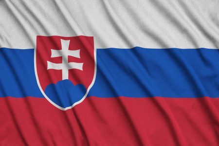 Slovakia flag is depicted on a sports cloth fabric with many folds. Sport team waving banner